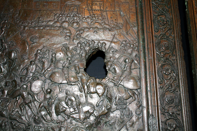 Metalic door depicting battle scenes